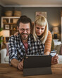© Miljan Živković - adult happy couple man and woman shopping online hold credit card