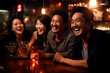 Young men of Asian appearance, partying and drinking at a bar, merrily discussing an interesting topic