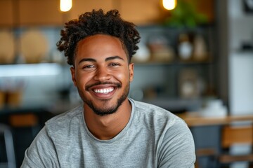 Wall Mural - A man with a beard and a smile is sitting at a table