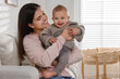 © New Africa - Happy young mother with her baby in living room