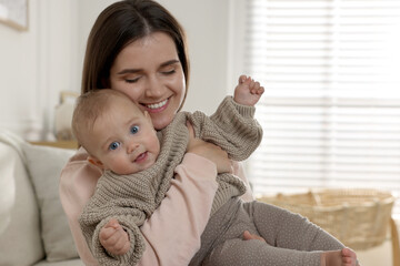 Wall Mural - Happy young mother with her baby at home