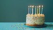 © Tida - Colorful birthday cake with lit candles - A vibrant birthday cake with sprinkles and lit candles ready for celebrating a festive occasion