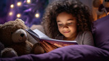 Little child kid is reading the storybook in evening in dark, sleeping in the bed, hugging her toy bear doll.