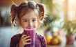 A young girl drinking a homemade fruit smoothie, emphasizing the importance of introducing healthy habits early in life.