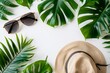 A white background featuring a straw hat, stylish sunglasses, and vibrant palm leaves arranged together