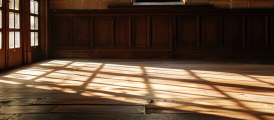 Poster - The sunlight is streaming through the window, creating shadows on the hardwood flooring of the building, adding tints and shades to the rectangular wood stain patterns