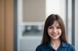 © PNG&Background Image - Happy at work concept. Cheerful young woman in a blue shirt standing against a bright office background with copy space.