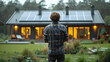 A worker looks at a private modern house with solar panels