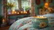  a close up of a lit candle on a bed in a room with a flowered bedspread and a window.