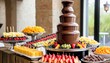 chocolate fountain catering machine with fruit skewers on rustic buffet table
