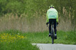 Radfahrer in langer Radbekleidung auf einem Crossfahrrad auf einem asphaltierten Radweg im Frühjahr
