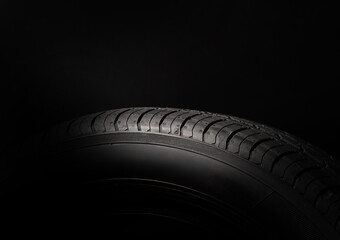 Car summer tire on black background with copy space