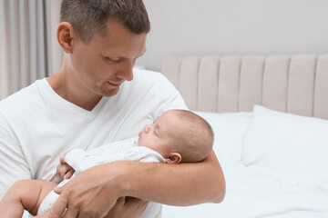 Wall Mural - Happy father holding his cute sleeping baby at home