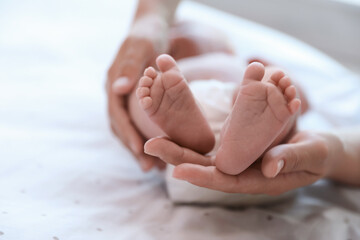 Canvas Print - Mother and her newborn baby on bed, closeup