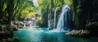 A majestic waterfall flows in the heart of a lush forest, surrounded by towering trees and a serene natural landscape of fluvial landforms