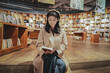 © 昊 周 - Serene Bookstore Moment: Young Woman Engrossed in Reading