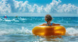 A little girl in an inflatable ring plays and swims on the beach