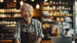 Cheerful elderly man with an infectious smile behind the counter of a traditional cafe.