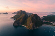 Aerial view of cliffs in the sea, yachts are sailing nearby, mountains covered with tropical forest. El Nido, Palawan, Philippines.