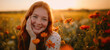 Joyful freckled girl among sunset wildflowers