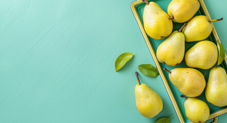 Wall Mural - Fresh organic yellow pears in a tray on a blue background. Copy space. Top view.