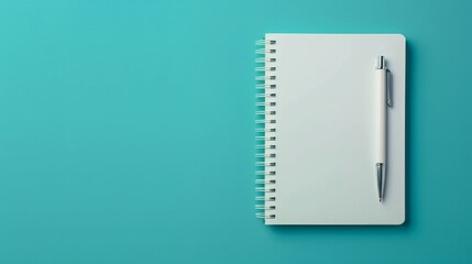 Crisp white notebook with silver pen on a vibrant blue backdrop invites creativity. A pristine notebook awaits the flow of ink