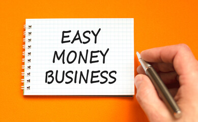 Easy money business symbol. Concept words Easy money business on beautiful white note. Beautiful orange background. Businessman hand. Easy money business concept. Copy space.