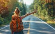 © Janjira - Woman enjoying summer travels, backpacking and hitchhiking with thumbs up, road trip freedom beckons.