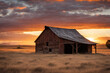 Rural wooden barn with an open window framing a surreal southwest sunset in the distance
