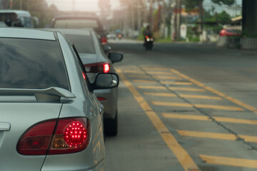 Wall Mural - Rear side of car with turn on brake light. Traffic jam on the asphalt road with yellow line and bokeh light background.