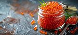 Fototapeta Natura - glass jar with red caviar accompanied by a spoon