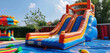 A colorful bouncy castle for the kids' play area and an inflatable bounce house for the backyard are combined into a water slide