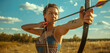 Confident young woman wearing a sport full dress looking to camera practicing archery in a field