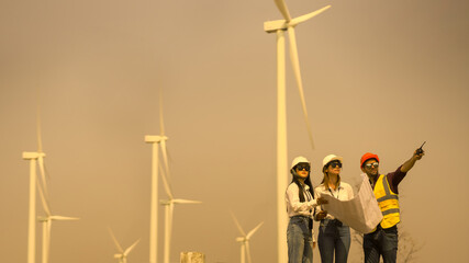 Young man and woman maintenance engineer team. two engineer operate wind turbine. Engineer and worker discussing on a wind turbine farm. Wind Turbine. Maintenance Workers. renewable energies..