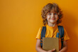 Adorable pupil with a book and backpack, vivid backdrop, close up shot with copy space, back to school concept.