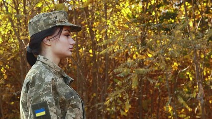 Wall Mural - Female servicewoman brave confident soldier dressed in the camouflage military uniform, velcro patch symbol of independence. Armed Forces of Ukraine. Woman serving in ukrainian army troops
