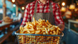 Close-up of a Chef Serving a Heaping Basket of Golden Crispy French Fries. Fried potatoes.