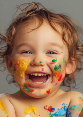 Wall Mural - Laughing child with splashes of colorful paint 