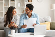 © Prostock-studio - Hindu couple planning finances with documents and laptop