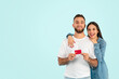 © Prostock-studio - Happy European couple holds credit card against blue backdrop