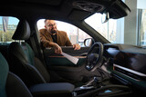 Fototapeta Młodzieżowe - Young man inspects the interior of a new car