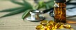 Cannabis oil pills and a stethoscope on a wooden table. Transparent yellow gel capsules and amber glass dropping bottle on a table with cannabis leaves and stethoscope