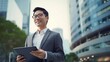 © Exnoi - A man wearing a suit and glasses is holding a tablet in his hand
