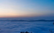 Un mare di nuvole bianche  e di nebbia riempie le valli sotto le montagneal tramonto 