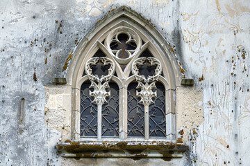 Wall Mural - A detailed view of a Gothic window, its intricate tracery and weathered stone standing out against a pure white background.