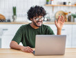 © kucherav - Portrait of Smiling successful young indian man freelancer or student working using laptop to work remotely from home
