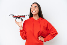 Young Caucasian Woman Holding A Drone Isolated On White Background Posing With Arms At Hip And Smiling