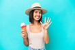 Young caucasian woman holding an ice cream isolated on blue background counting five with fingers