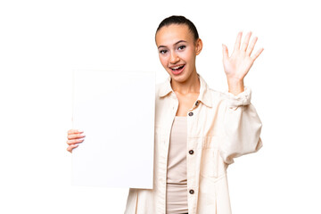 Wall Mural - Young Arab woman over isolated background holding an empty placard and saluting