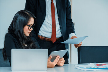 Senior executive manager and young businesswoman working in meeting room in the office. The woman is secretary or translator. International business language translation concept. uds